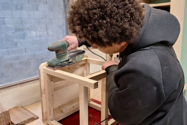 Jeune en train de poncer une chaise