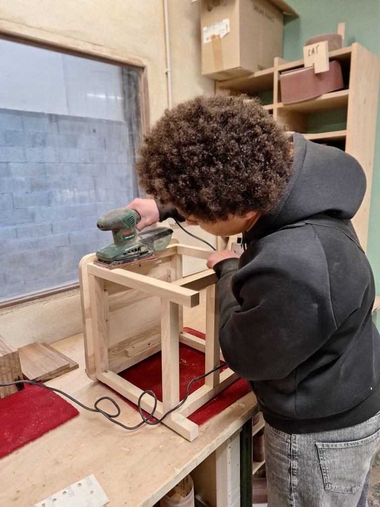 Jeune en train de poncer une chaise